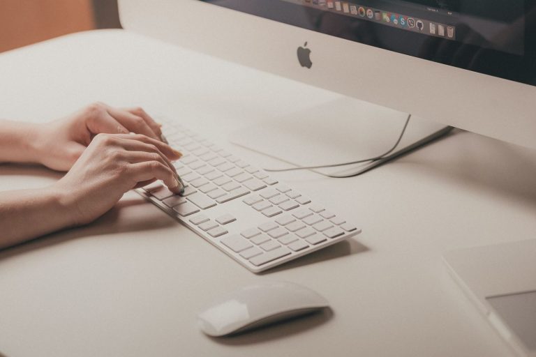 une personne écrit sur son clavier d'ordinateur une charte éditoriale
