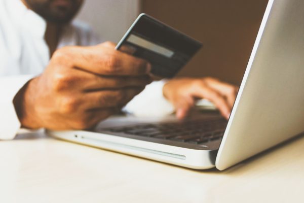 un homme fait ses achats en ligne avec un ordinateur portable