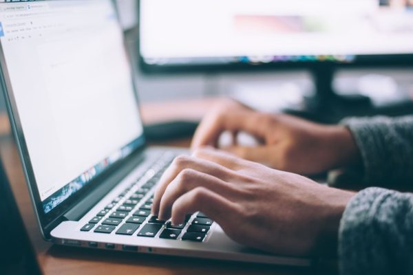 un homme rédige son site web sur son ordinateur portable